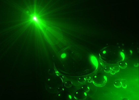Illustration of a light beam attracting oil drops on the surface of water
